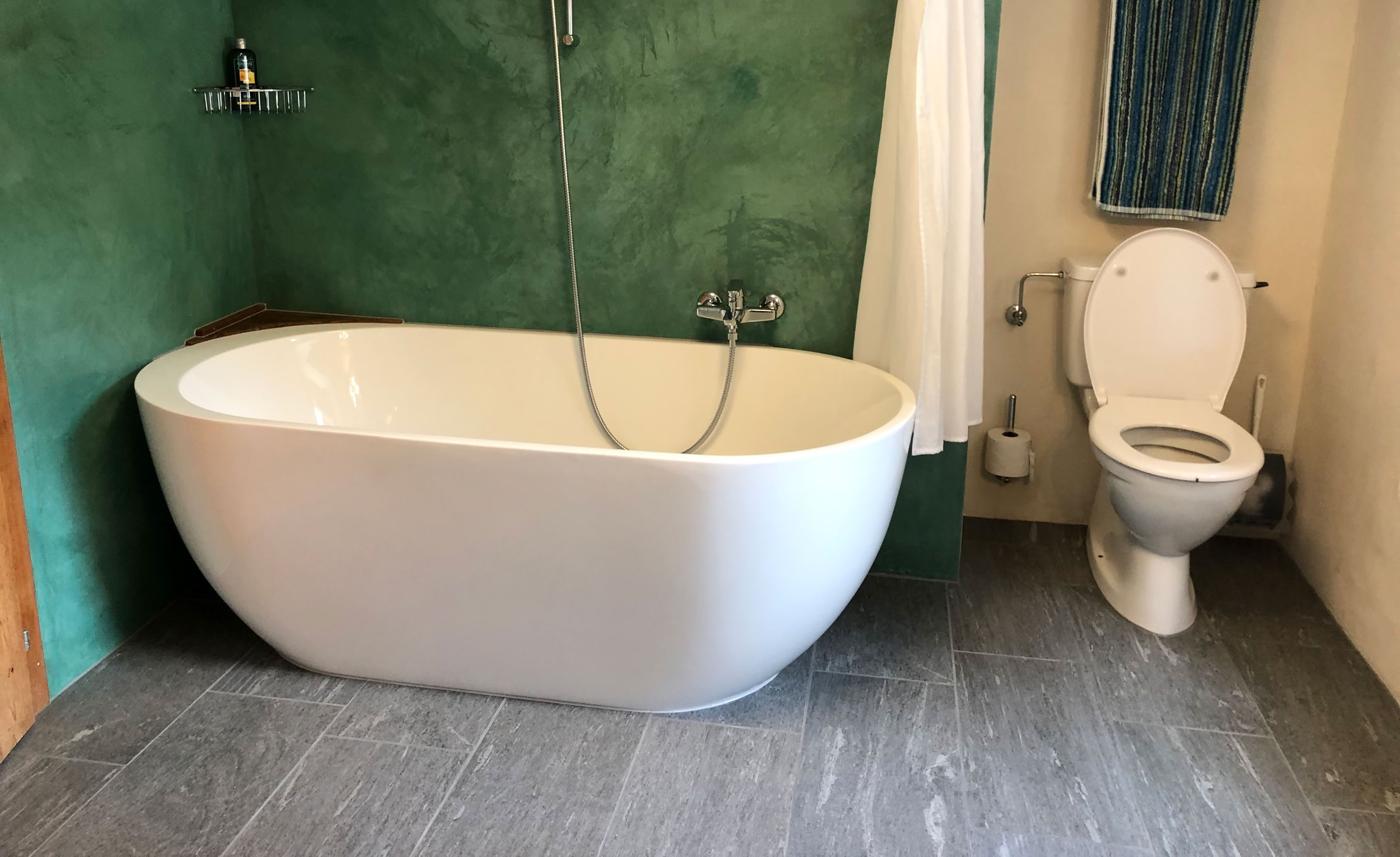 Eine sanfte Badsanierung mit neuen Fliesen (mit Valser Quarzit Print) und einer Acryl-Badewanne