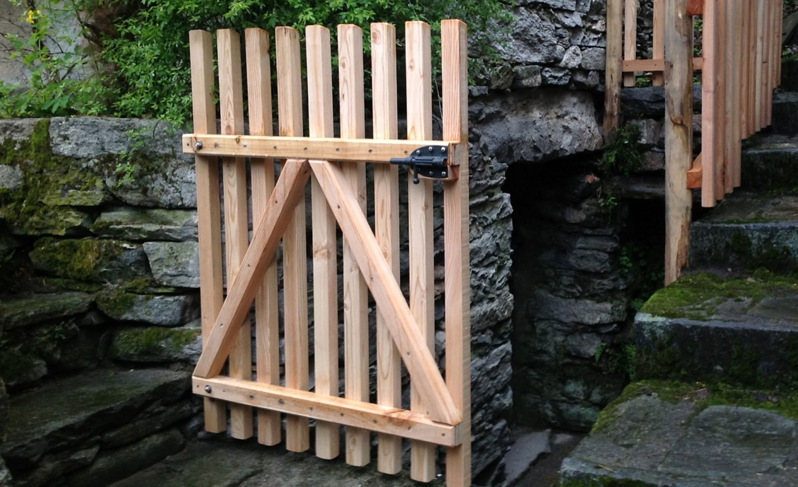 Angefertigtes Gartentor Holz aus Lärche an einer Granit-Steinmauer