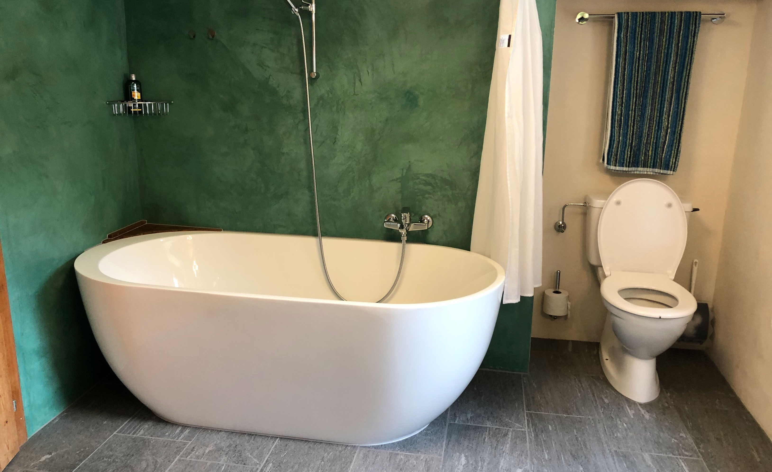 Eine sanfte Badsanierung mit neuen Fliesen (mit Valser Quarzit Print) und einer Acryl-Badewanne
