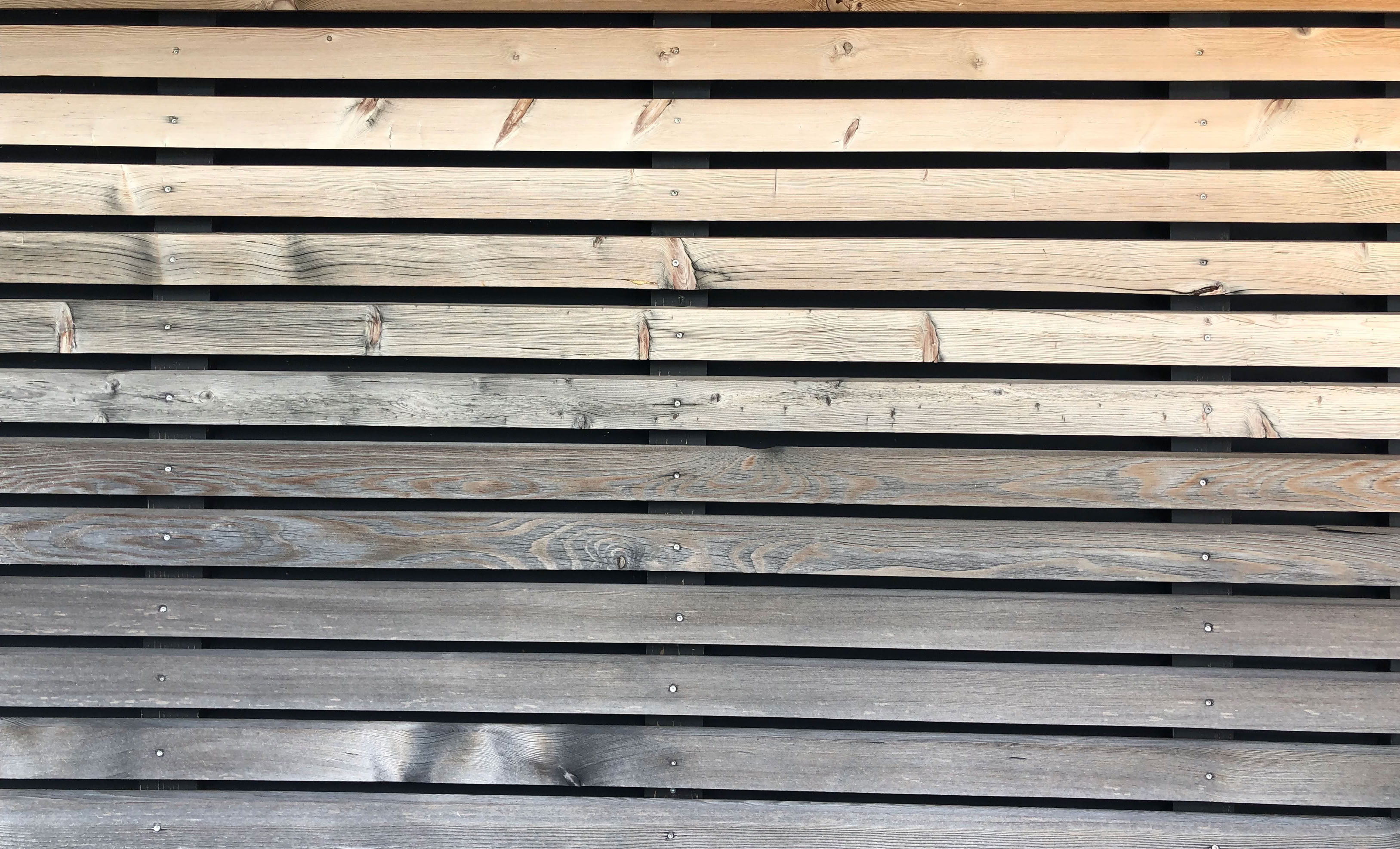 Übergang zur Vergrauung durch eine Teilbewitterung einer Fassade. Eine Reinigung wie bei einer Terrassenpflege ist hier unnötig
