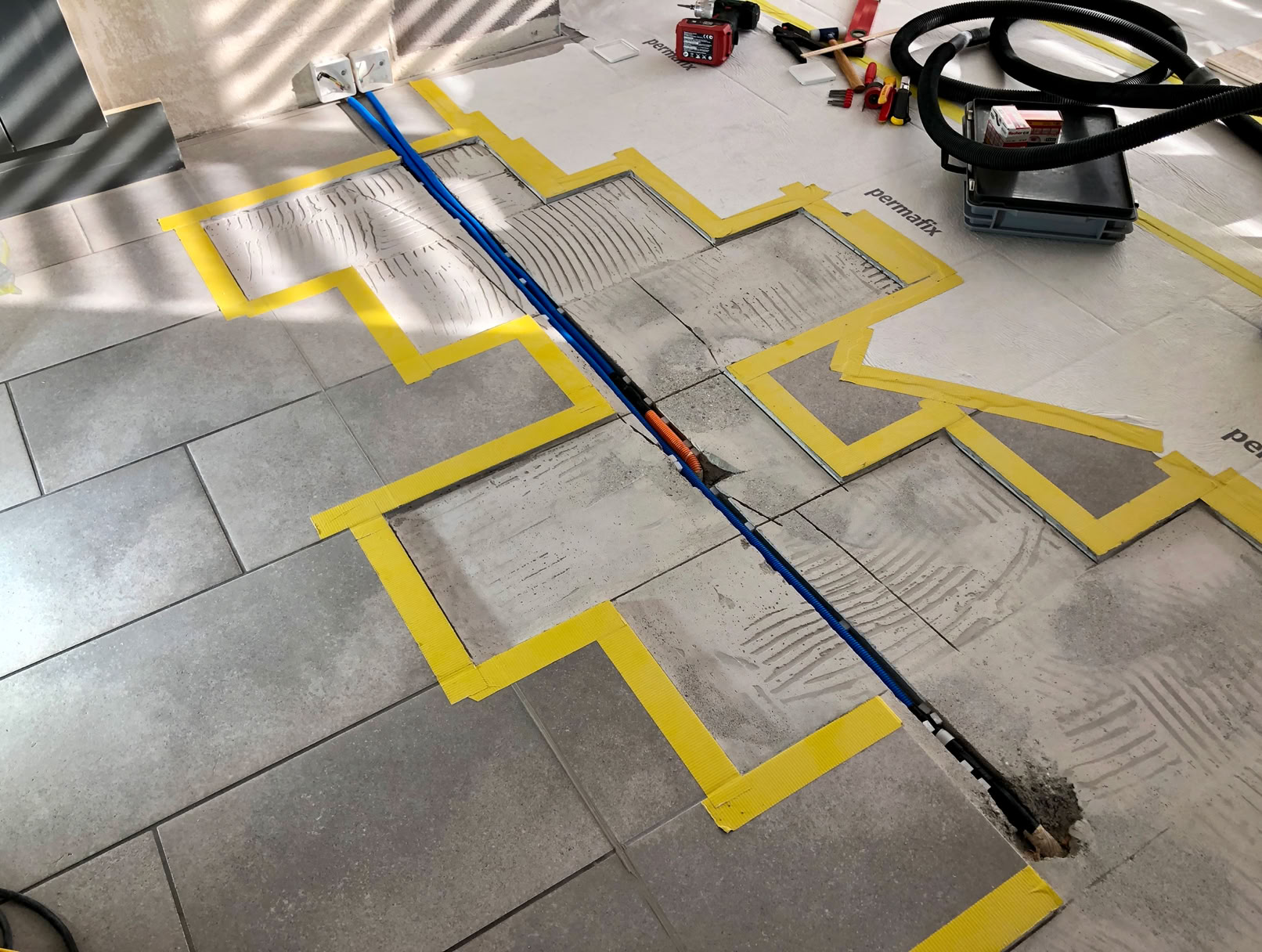 Küchensanierung durch Versetzung der Elektroleitungen unterhalb der Fliesen für die Erweiterung rechts