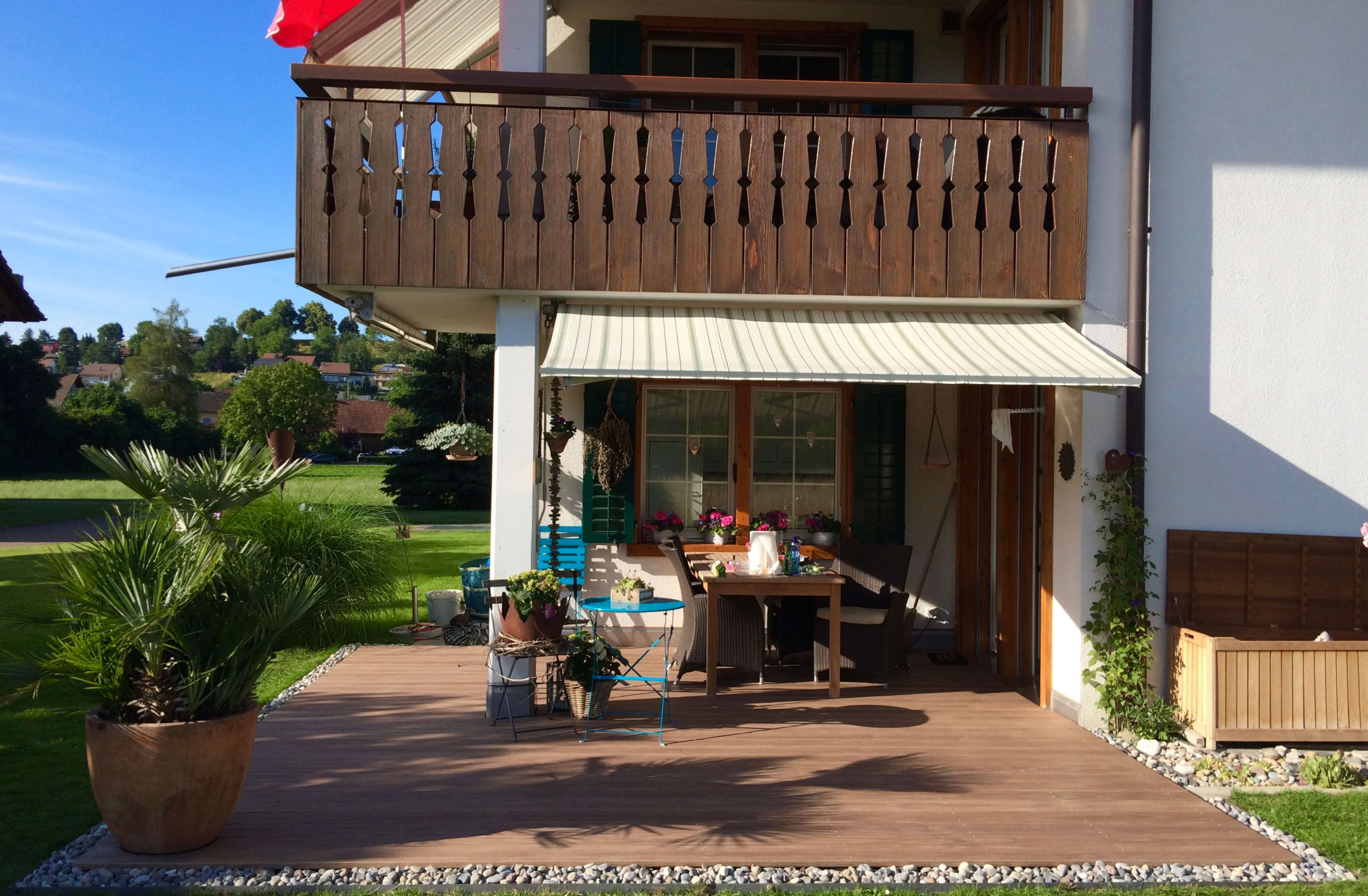 Ein frisch saniterter und schöner Gartensitzplatz wie hier bestehend aus einer hochwertigen Holzterrasse und mit Steinen eingefasst.