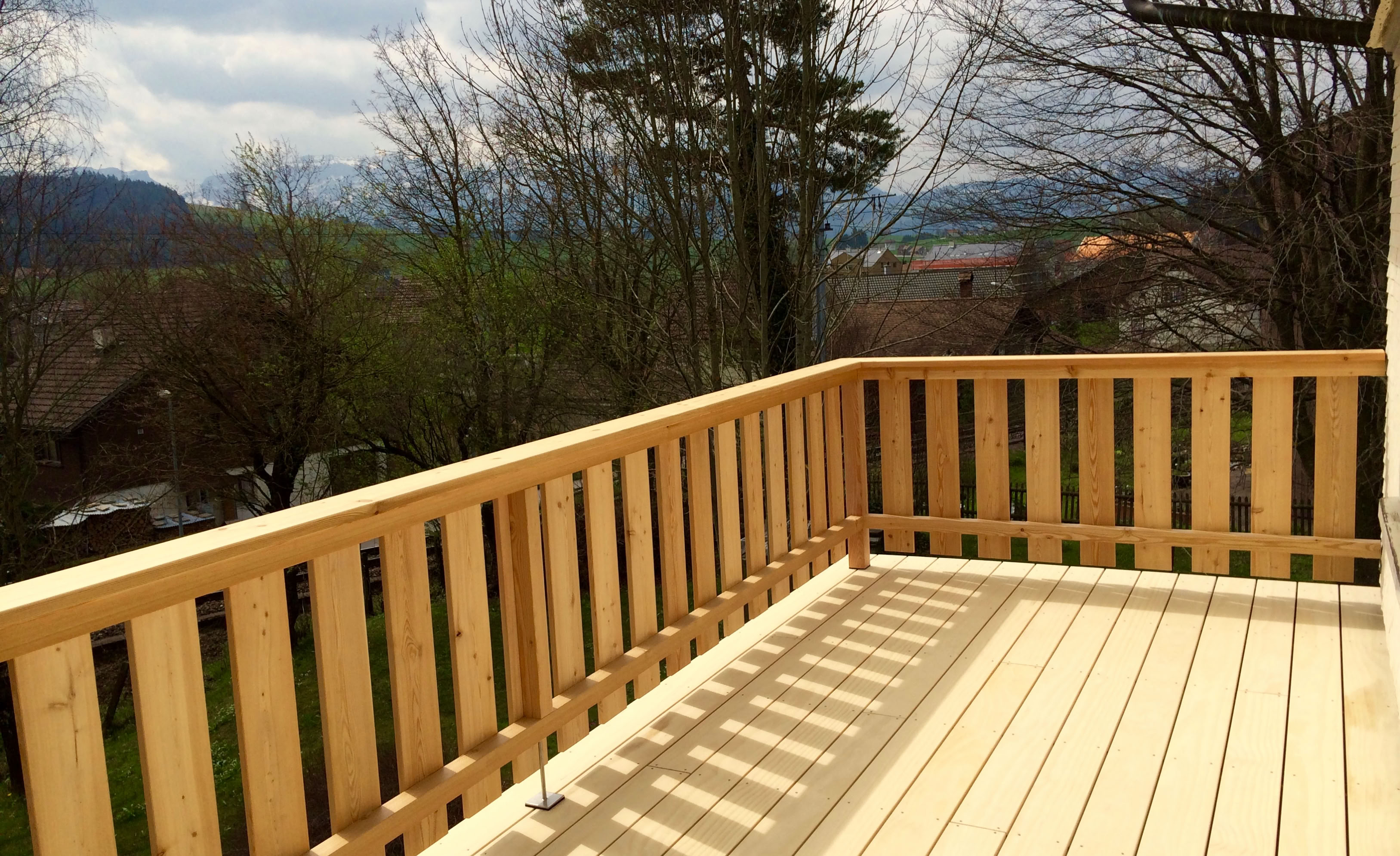 Fertig sanierter Balkon. Geschmückt mit einer hochwertigen Accoya Terrasse und einem Lärchenholz-Gelander